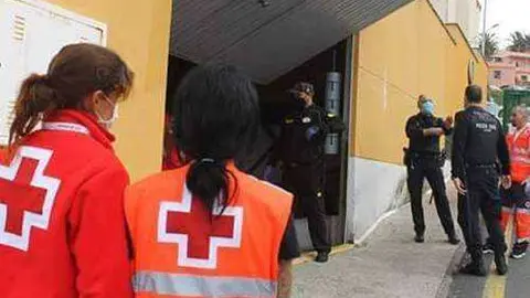 Voluntarios de Cruz Roja y polic&iacute;as en uno de los accesos a La Libertad (J. CHELLARAM)
