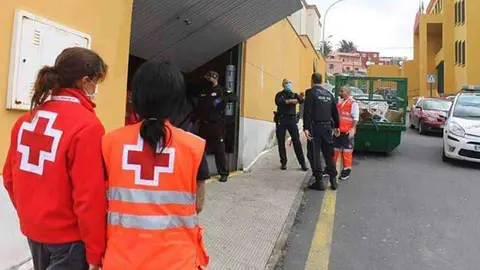 Voluntarios de Cruz Roja y polic&iacute;as en uno de los accesos a La Libertad (J. CHELLARAM)