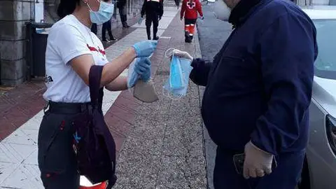 Una voluntaria de Cruz Roja reparte mascarillas junto al Mercado Central (CEDIDA)