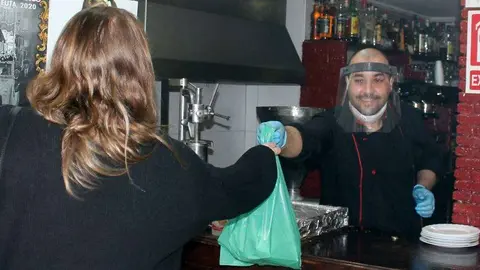 Un trabajador atiende a una cliente tras la reapertura de los establecimientos de hosteler&iacute;a (C.A./ARCHIVO)