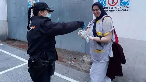Una agente de Polic&iacute;a entrega una mascarilla a una viandante (C.A./ARCHIVO)