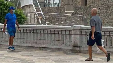 Dos viandantes caminan por La Marina (C.A.)