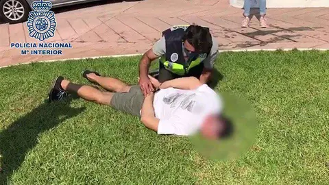 Un agente esposa a uno de los detenidos durante la operaci&oacute;n (POLIC&Iacute;A NACIONAL)