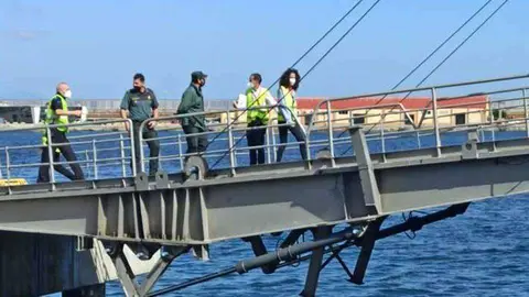 Agentes de la Guardia Civil y personal de la compa&ntilde;&iacute;a suben al barco (C.A.)