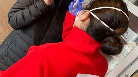 Una voluntaria de Cruz Roja toma la temperatura a una mujer a la entrada del Hospital Universitario (C.A./ARCHIVO)