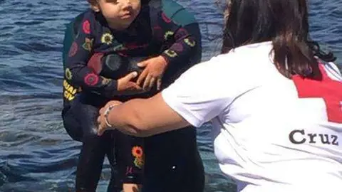 Una ni&ntilde;a es rescatada del agua por un agente de la Guardia Civil en Ceuta (MINISTERIO DEL INTERIOR)