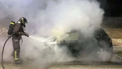 Un bombero trata de sofocar el fuego declarado en uno de los dos veh&iacute;culos (SEIS)