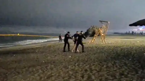 La Guardia Civil, interceptando a un inmigrante en la playa del Tarajal