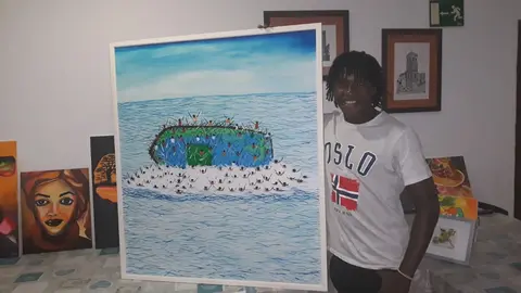 El artista Sory Traore mostrando alguna de sus obras