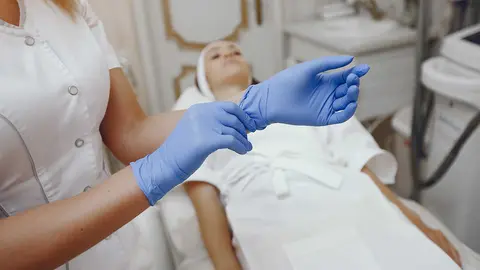Cosmetologist treats client's skin. Woman with cosmetologist. Lady in a beauty studio.
