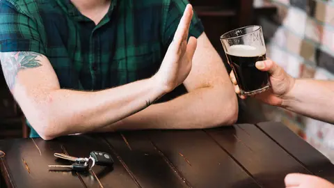 hombre rechazando vaso de alcohol