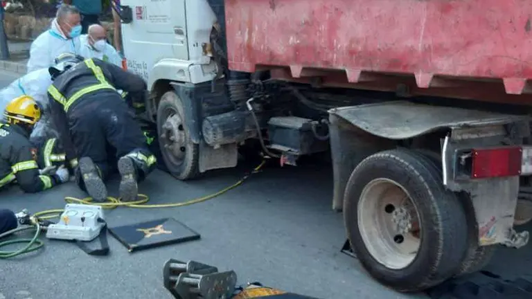 Los bomberos trabajan bajo la furgoneta accidentada (C.A.) ACCIDENTE LA MARINA
