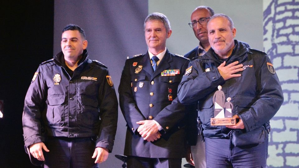 El jefe superior de la Policía, Francisco López Gordo, recoge el galardón junto a dos agentes (C.A.)