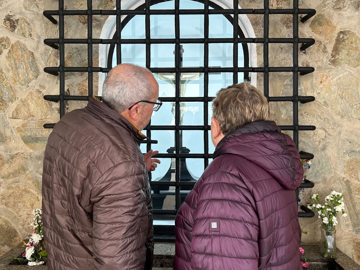 Una pareja se acerca al Cristo de los Afligidos tras regresar a su hornacina / E. Arteaga